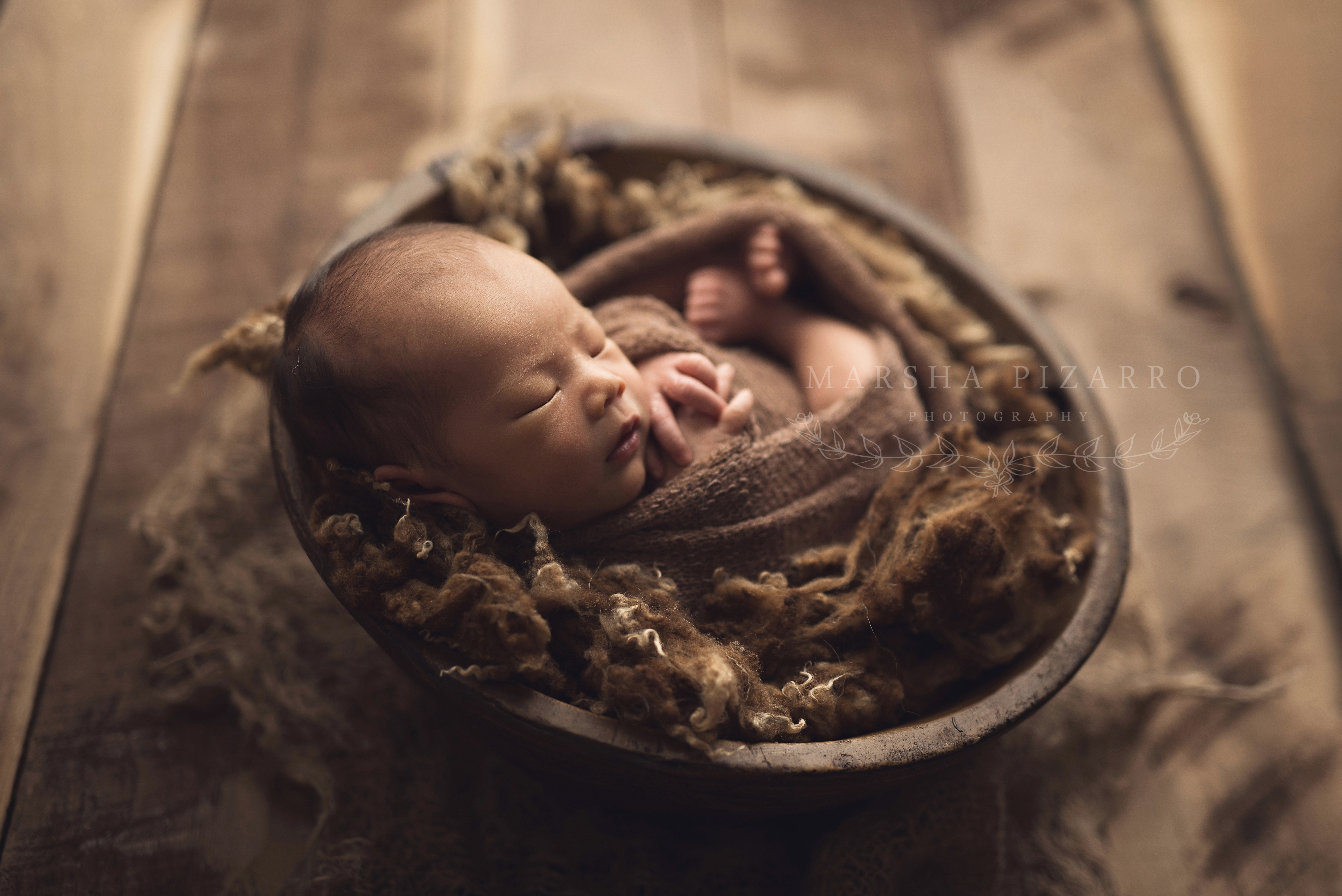 baby boy in a brown bucket